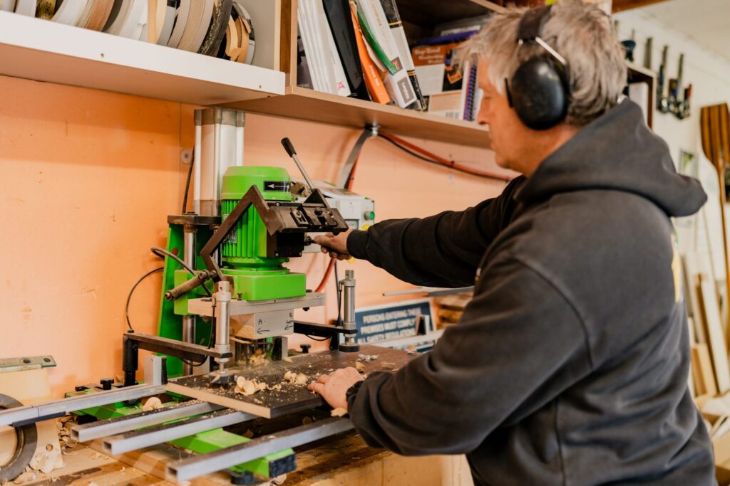 Paragon Portables craftsman working with drilling machine to prepare cabinetry for portable homes.