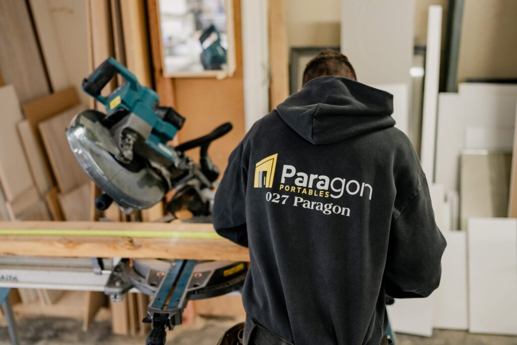 Craftsman at work cutting timber for building homes and portable houses NZ, highlighting skilled residential builders and new home build NZ craftsmanship.
