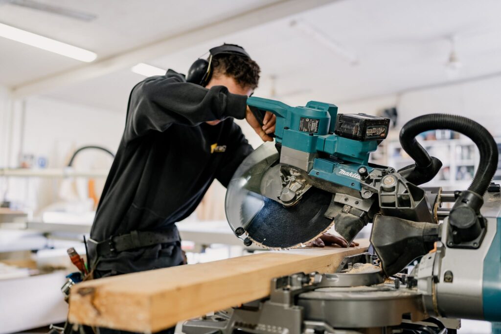 Builder wearing Paragon Portables uniform in workshop, symbolising trusted tiny home builders NZ specialising in relocatable, portable and affordable homes.